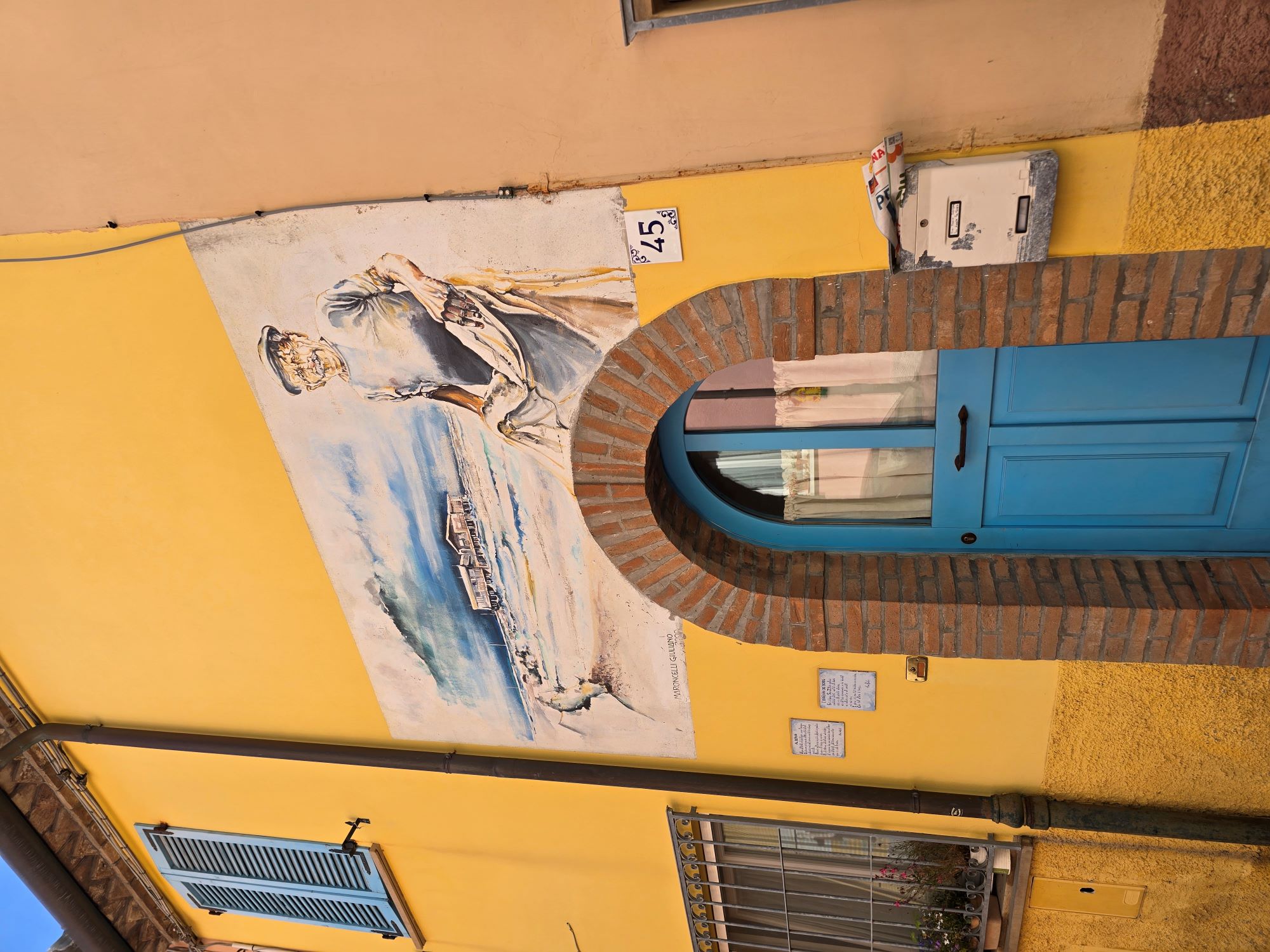 Fisherman mural painted on a yellow house in Rimini's old fishing quarter